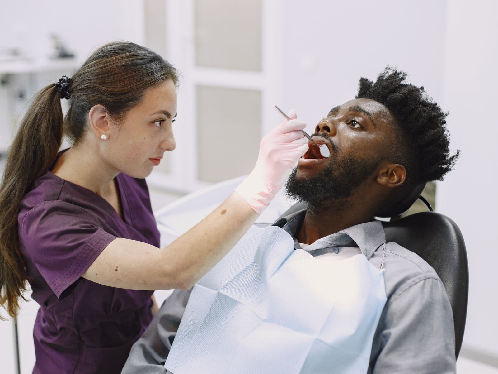 Odontóloga examinando a un paciente durante una consulta dental
