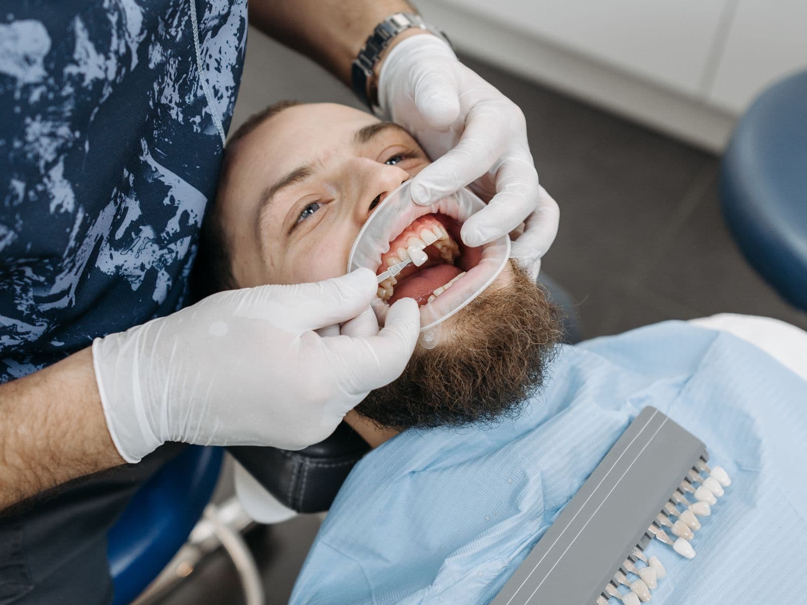 Odontólogo revisando una pieza dental durante un tratamiento restaurador