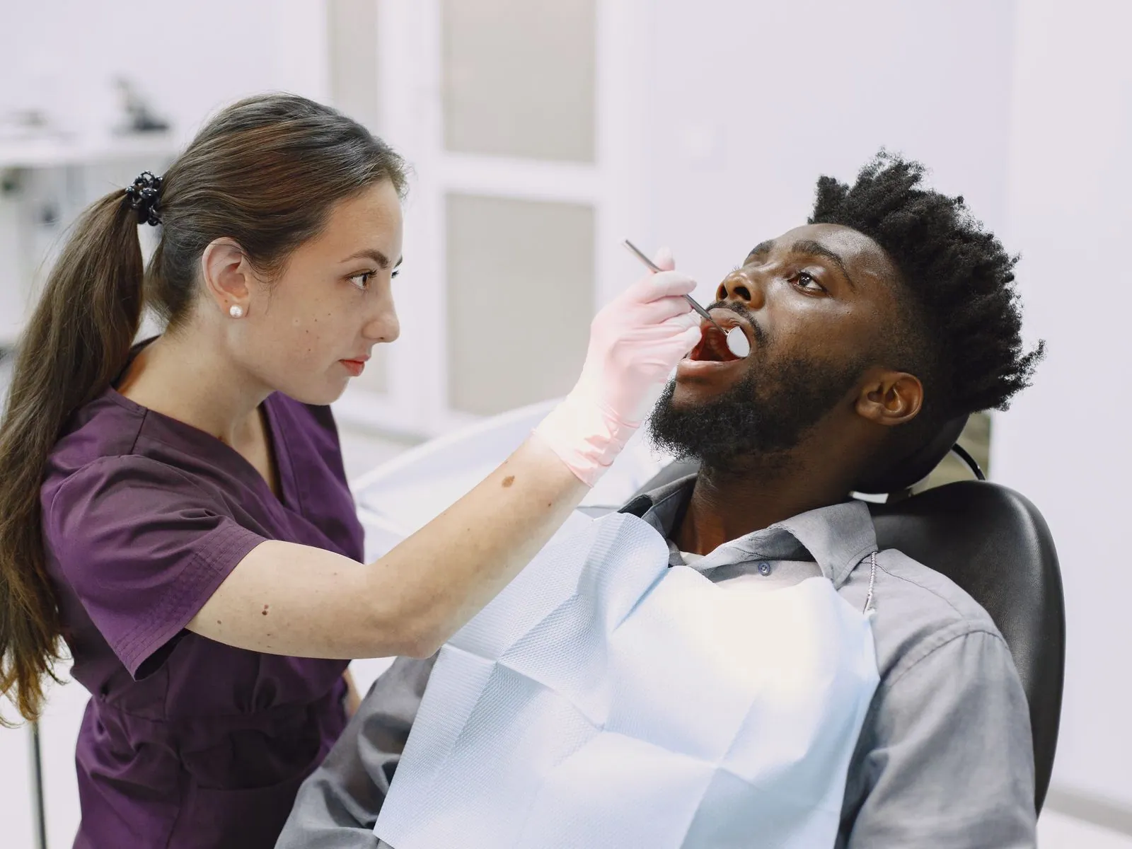 Odontóloga examinando a un paciente durante una consulta dental